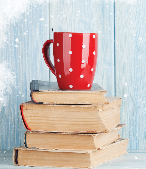 Red cup with white polka dots atop a stack of books