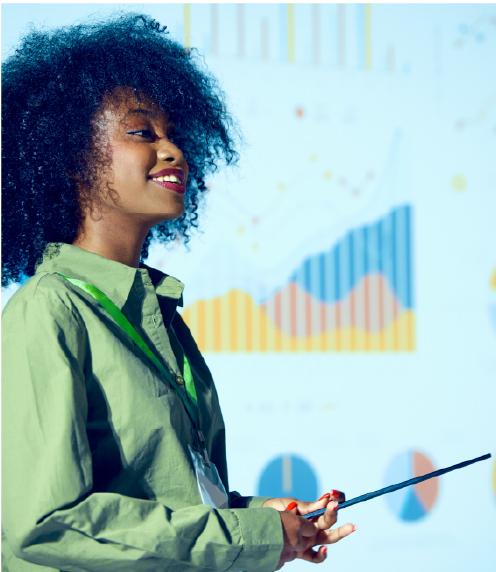 Woman standing in front of a slide deck presentation of charts